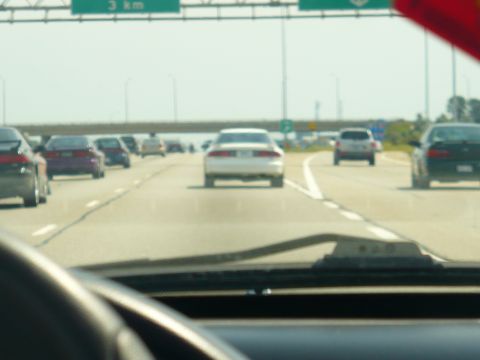 1993 Ford Probe - Multiple vehicles drive on a highway under a bright sky.