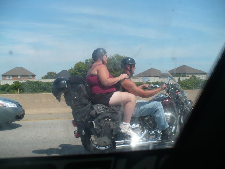 Motorcycle with two riders and luggage on a highway.