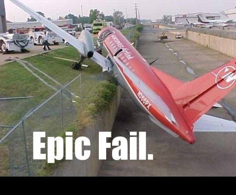 1988 Mercury Grand Marquis - An airplane has veered off the runway and is stuck in the grass next to a ditch.