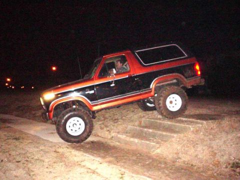 1984 Ford Bronco - This 1984 Ford Bronco is captured in a three-quarter front view as it navigates a set of stairs in the dark.