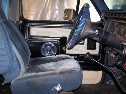 1986 Ford Bronco - Close-up view of the interior door panel and seat, a blue speaker.