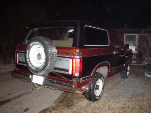 1984 Ford Bronco - This Ford Bronco features a two-tone paint scheme and a rear-mounted spare tire.