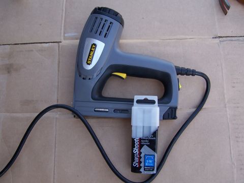 1986 Ford Bronco - A Stanley staple gun and a package of 5/16" (8mm) staples are shown on a cardboard surface.