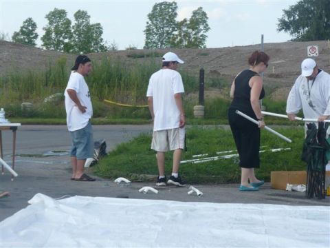 1993 Ford Probe - Several people are seen working together to set up what appears to be an outdoor event structure.