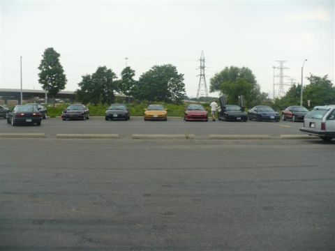 1993 Ford Probe - A group of cars are parked in a lot on a cloudy day.