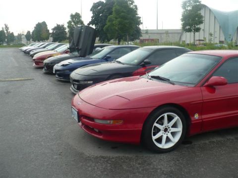 1993 Ford Probe - A line of Ford Probes, including one with distinctive gullwing doors, are parked in a lot.