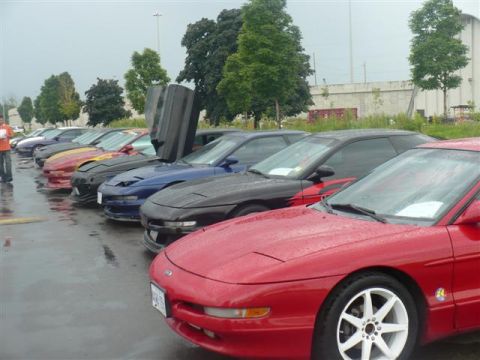 1993 Ford Probe - A line of Ford Probes are parked in a lot, with one red Probe in the foreground custom white rims.