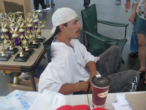 1993 Ford Probe - A man sits by a table displaying several trophies, with a coffee cup nearby.