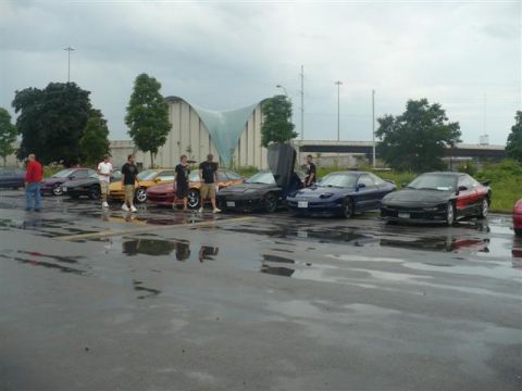 1993 Ford Probe - A group of Ford Probes are gathered in a parking lot on a rainy day.