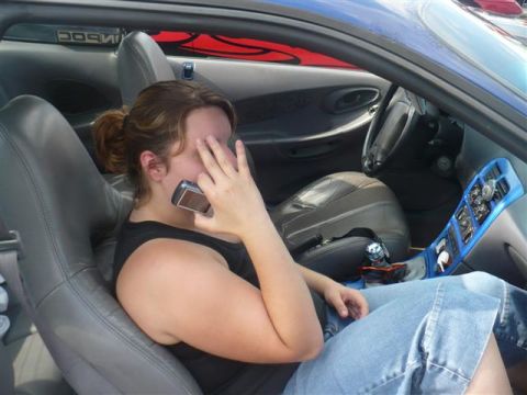 1993 Ford Probe - Interior view of a car with a woman on the phone, showing blue accents on the center console.