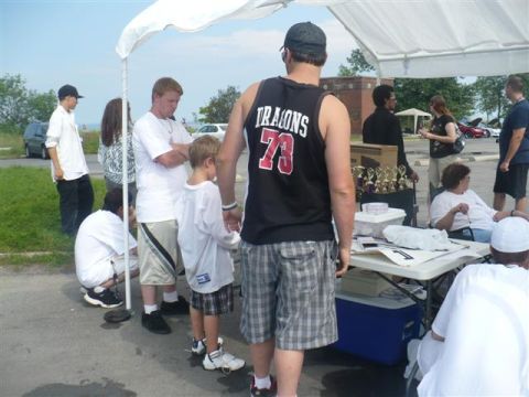 1993 Ford Probe - Outdoor gathering with people under a tent, trophies visible on a table.