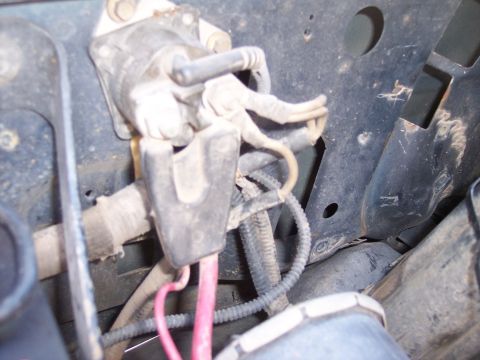 1996 Ford Bronco - Close-up under the hood of a starter solenoid mounted to a dirty black inner fender panel, with corroded brass terminal studs, spade connec…