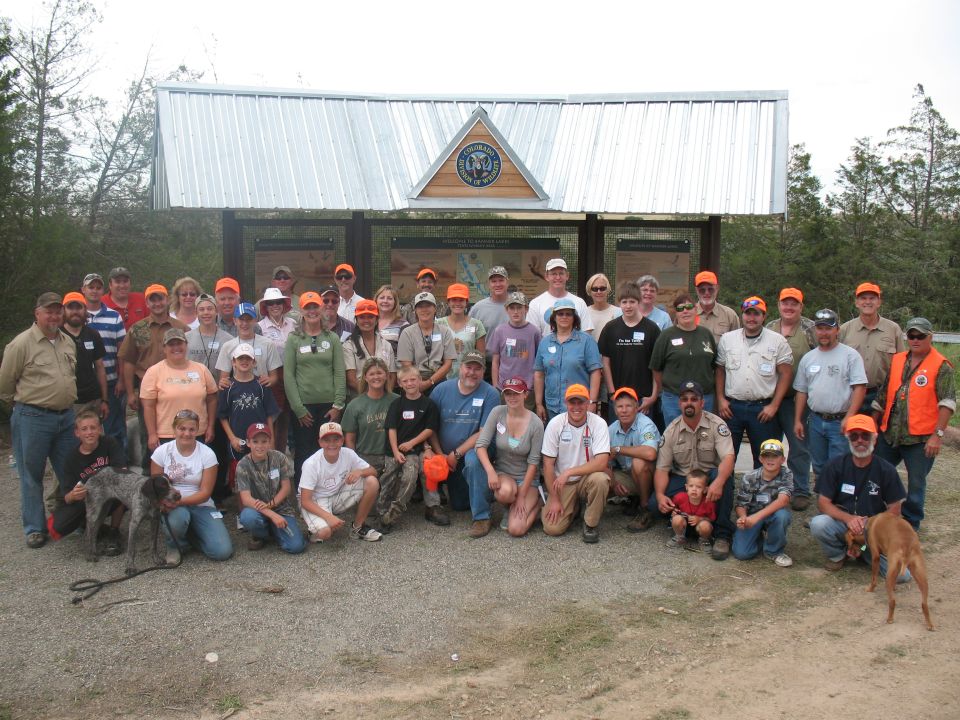 Group of people and dogs in front of a park building.