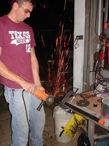 1996 Ford F-150 - A person wearing a maroon t-shirt and blue jeans is using an angle grinder, creating a shower of sparks. The person is wearing safety glass…