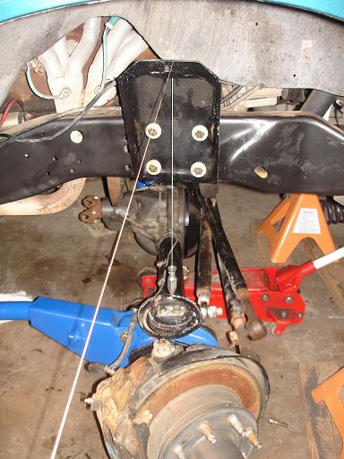 1996 Ford F-150 - This image shows the underside of a vehicle, focusing on the suspension components of the front axle. A black metal bracket is bolted to th…