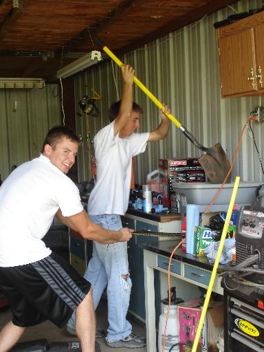 1996 Ford F-150 - Two young men are in a garage or workshop. One is holding a shovel above his head, and the other is holding a chain.