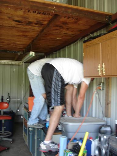 1996 Ford F-150 - Two people are bending over a workbench in what appears to be a garage or workshop setting. One person is wearing jeans and a white t-shirt…
