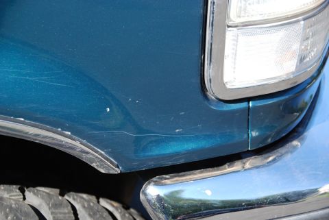 1996 Ford Bronco - Photograph of a teal Bronco's front fender, headlight and chrome bumper, not a technical document.