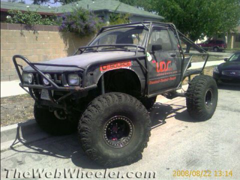 1990 Ford Bronco - Photo of a black lifted Toyota mini-truck rock buggy parked in a yard, not a technical document.
