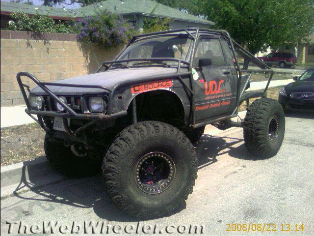 Black lifted Toyota pickup rock-crawler with large tires parked outdoors