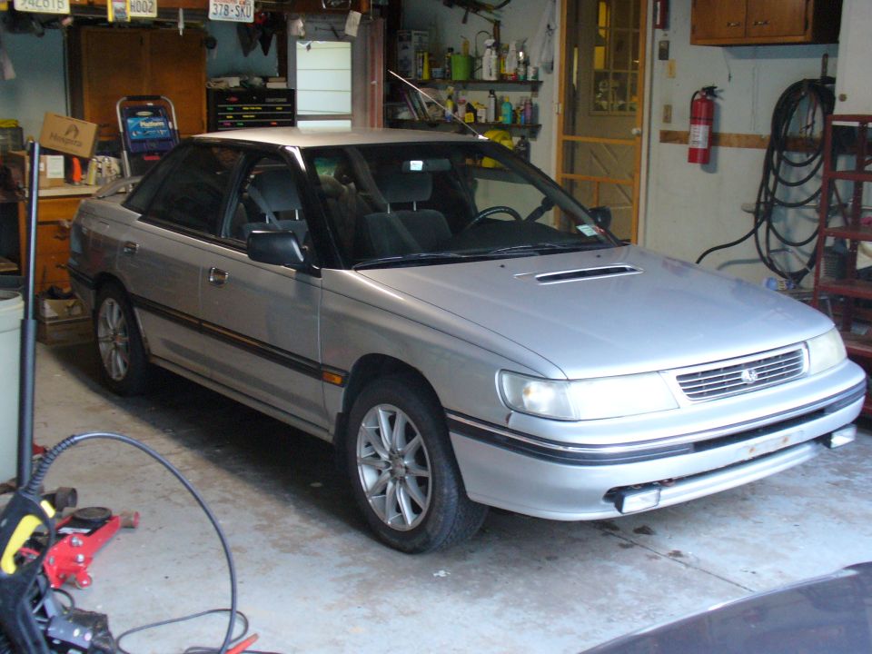 1994 Subaru Legacy sedan, silver, parked in a garage, 3/4 front driver's side view