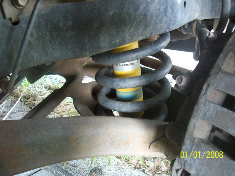 Photo of rear coil spring and suspension mount under a truck