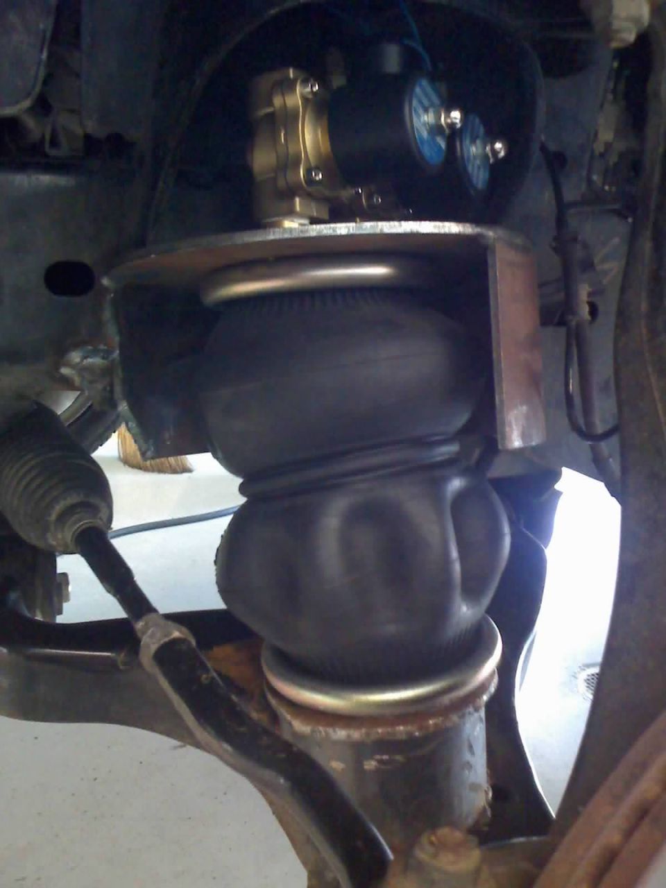 Air bag suspension conversion with solenoid valves installed in front wheel well of a Nissan Titan