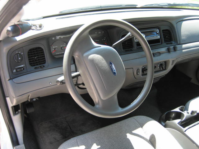 Interior view of a Ford Crown Victoria dashboard, steering wheel, and center console.