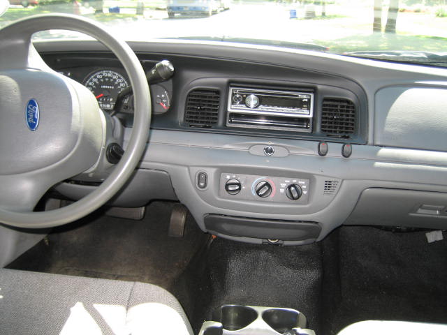 Interior of a 2003 Ford Crown Victoria showing dashboard, steering wheel, and center console.