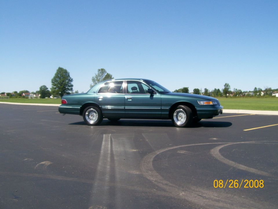 Dark green sedan parked on asphalt.