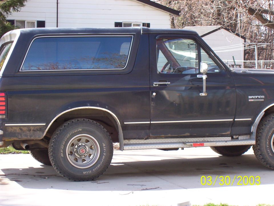 Black two-door Ford Bronco side view with BFGoodrich All-Terrain tires and diamond-plate rocker trim