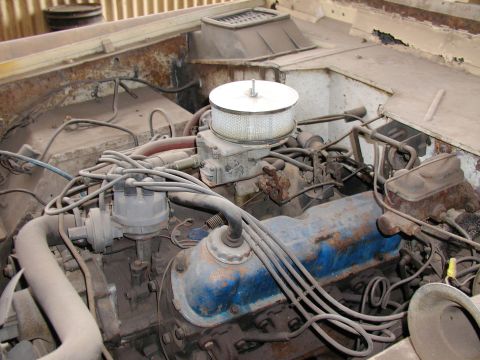 1971 Ford Bronco - The engine compartment shows a V8 engine with various components and wiring, indicating a vehicle's mechanical heart.