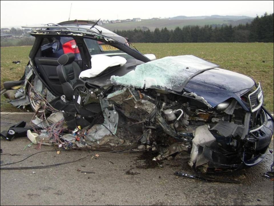 A wrecked dark blue sedan with extensive front-end damage and exposed interior.