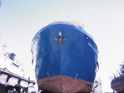 1991 Ford Bronco - The bow of a large blue and red ship is shown from a low angle, with the name "ROBERT G. BROWNLER" visible on its side. Another ship and pa…