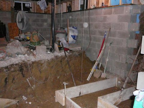 1997 Mercury Grand Marquis - This is a construction scene in a basement. There is a large concrete block wall, a dug-out area in the foreground, and various tools and m…
