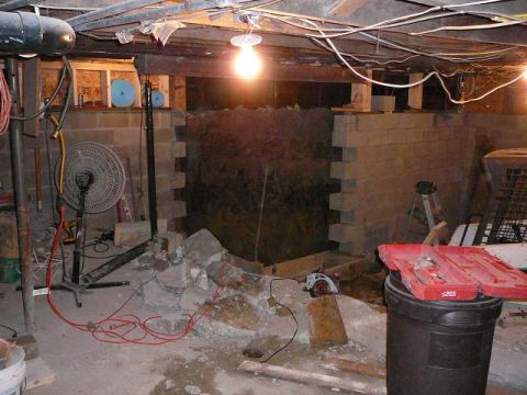 1997 Mercury Grand Marquis - This is a scene of a basement or crawl space with construction materials and tools. A large fan is visible on the left, and a red toolbox s…