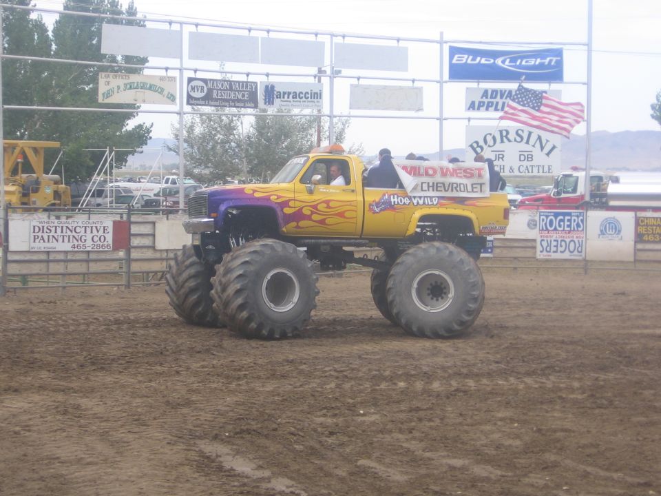 Yellow flame-painted Chevrolet monster truck at an arena event
