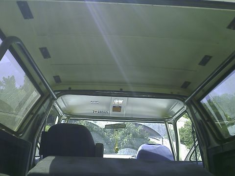 1990 Ford Bronco - Interior view of the headliner and roof structure of a classic SUV, possibly a 1990 Ford Bronco, with visible roll cage supports and afterm…