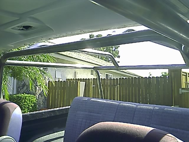 Interior view of a vehicle's roll cage with rear seats visible.
