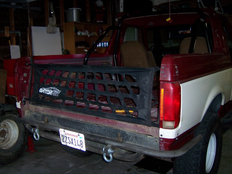 Three-quarter rear photo of a maroon truck with tailgate cargo net