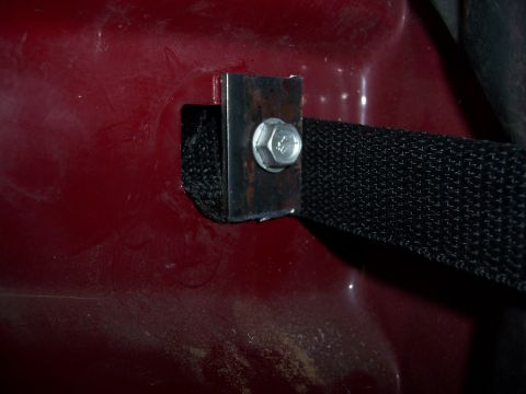 1991 Ford Bronco - A close-up view of a red vehicle's door latch assembly.