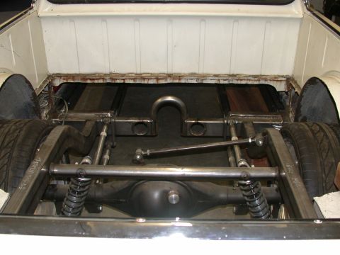 1964 Ford Ranchero - The rear suspension and chassis of a 1964 Ford Ranchero are visible, with a custom setup and wooden bed floor.