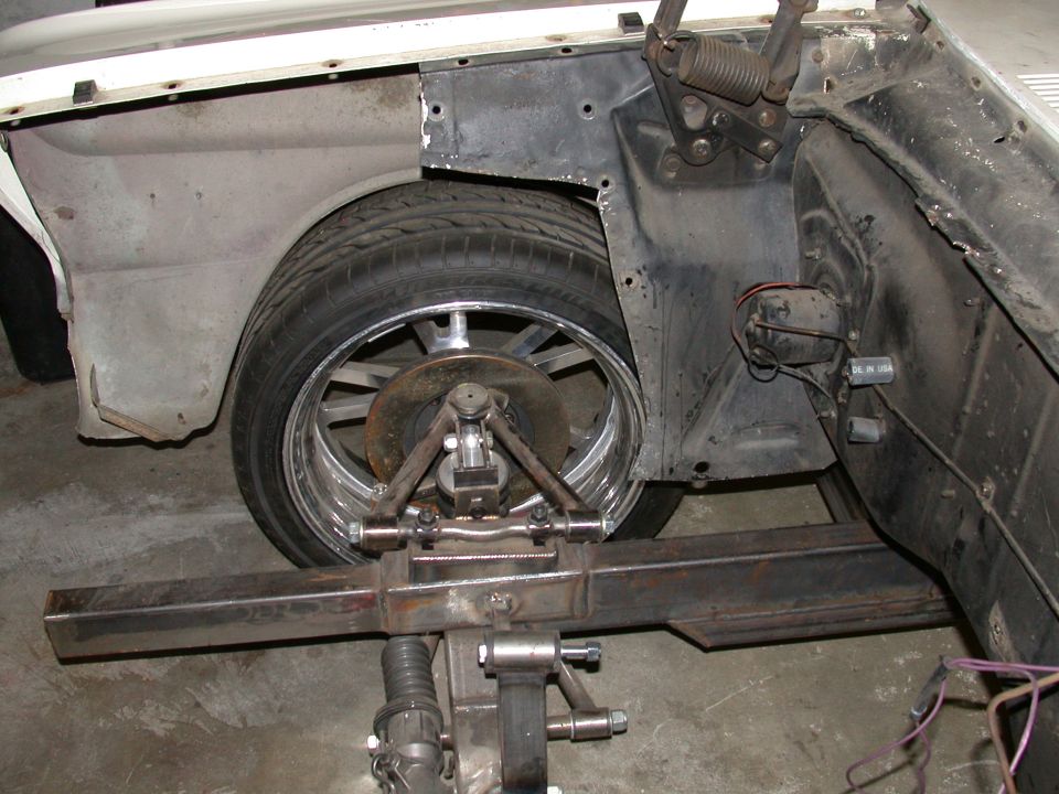 Front suspension with chrome wheel, brake rotor, tubular arm and tube frame on a project vehicle