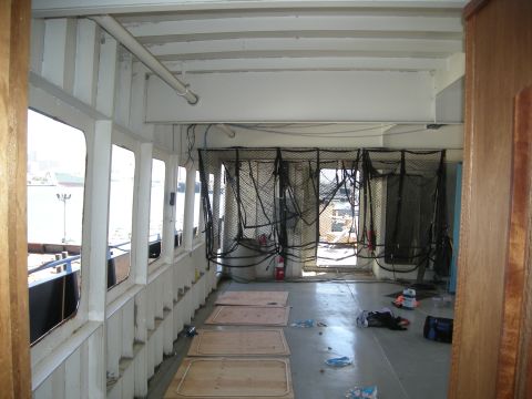 1991 Ford Bronco - The interior of a vessel shows a view through windows and netting, with floor panels and scattered items on the deck.