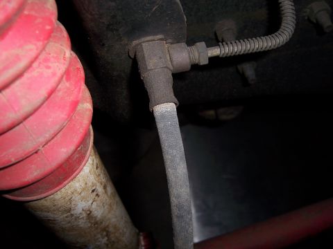1991 Ford Bronco - Detail shot of a vehicle's brake hose and a red suspension component, likely from underneath.
