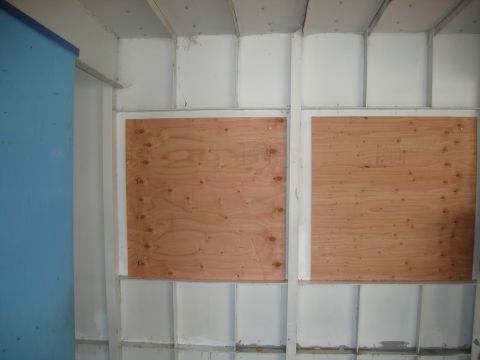 1991 Ford Bronco - Interior view of a building with plywood covering window openings.