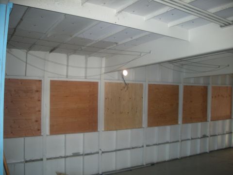 1991 Ford Bronco - Interior view of a building with multiple windows covered by plywood, a "SUPERMOTORS" logo in the corner.
