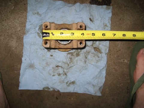 1995 Ford Bronco - A bearing housing is measured on a blue paper towel, with a yellow tape measure indicating its size.