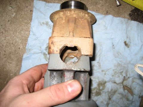 1995 Ford Bronco - A hand holds a rusty metal component, possibly from a vehicle's transmission or drivetrain.