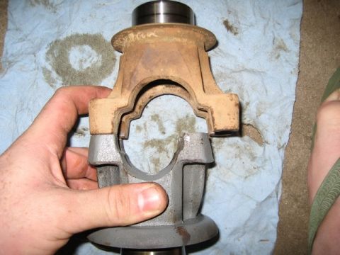 1995 Ford Bronco - Close-up of a driveshaft U-joint component, held by a hand over a blue shop towel.
